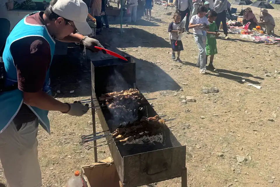 Grilling skewers over charcoal at a lively Naadam Festival — a taste of Mongolia’s culinary traditions