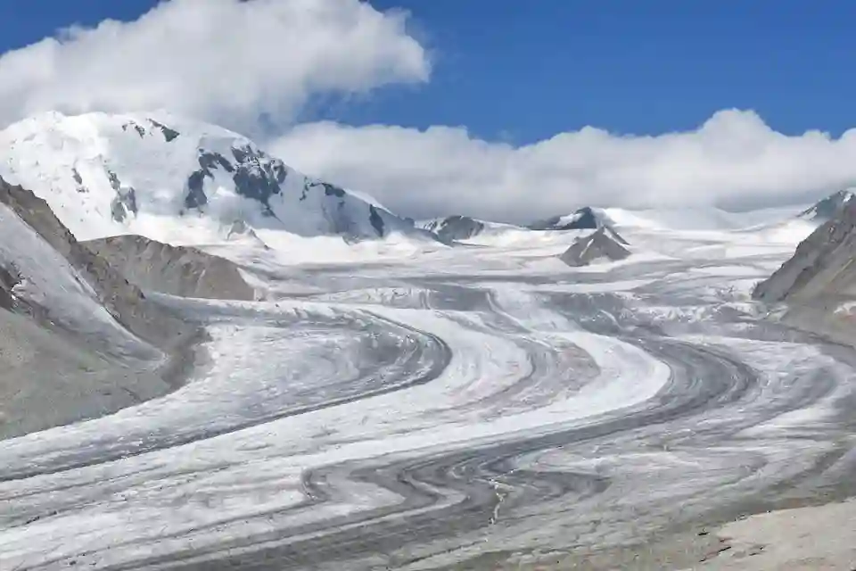 A sweeping glacier carves through the rugged peaks of Altai Tavan Bogd, showcasing Mongolia’s alpine beauty