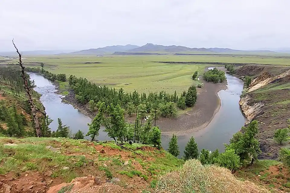 A winding river carves through Mongolia’s lush valley—showcasing nature’s artistry and geographic wonder.
