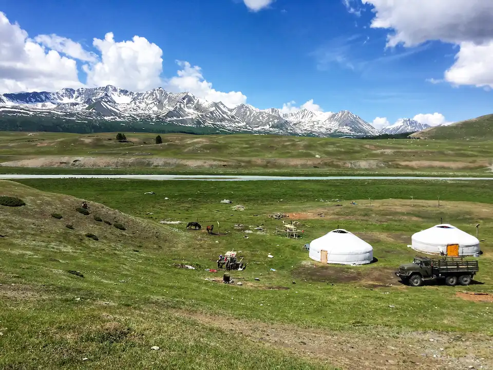 A nomadic family's ger camp beneath the snow-capped Altai Tavan Bogd mountains